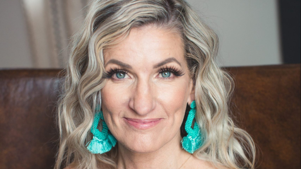 Woman in black blouse sitting on brown sofa with dangling turquoise earrings