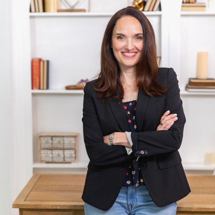 Sarah Walton invites women entrepreneurs time for you to get off the hamster wheel. Master the way you think about your business today. Sarah Walton in a black blazer and navy blue floral blouse.