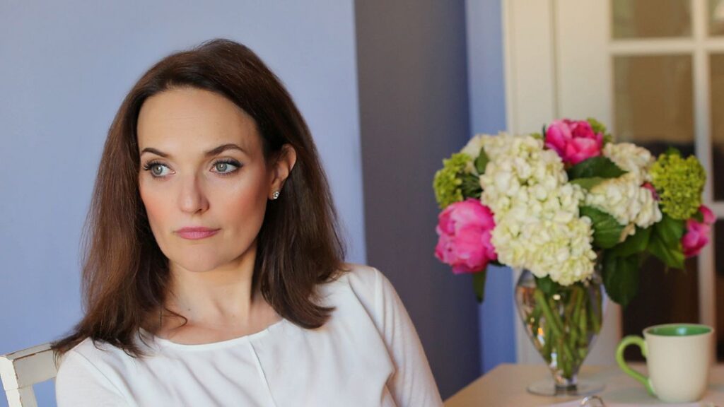 Woman entrepreneur journaling about money mindset and nervous system regulation for business growth or Sarah journaling about money mindset and nervous system regulation for business growth