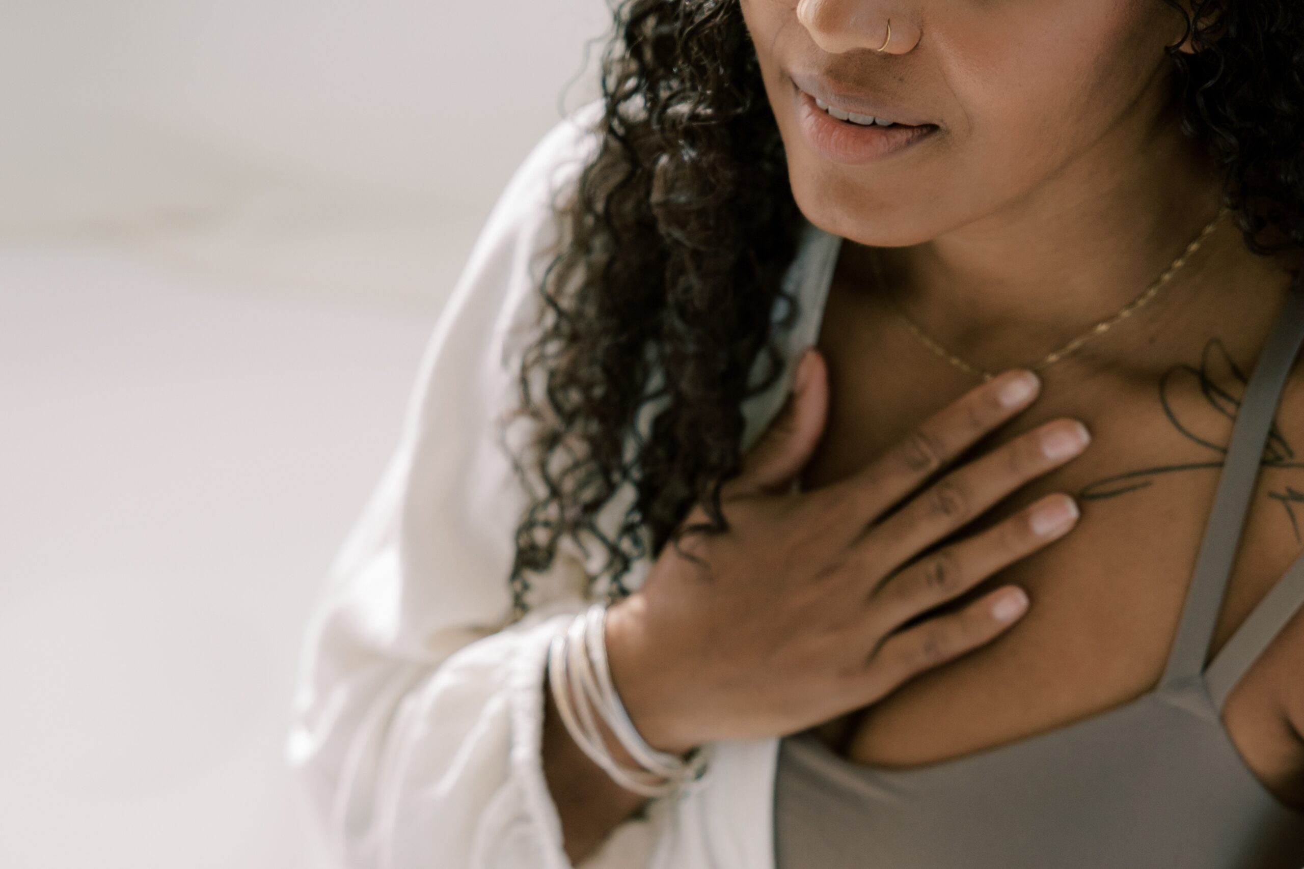 Woman smiling with hand on heart in grounding meditation gesture