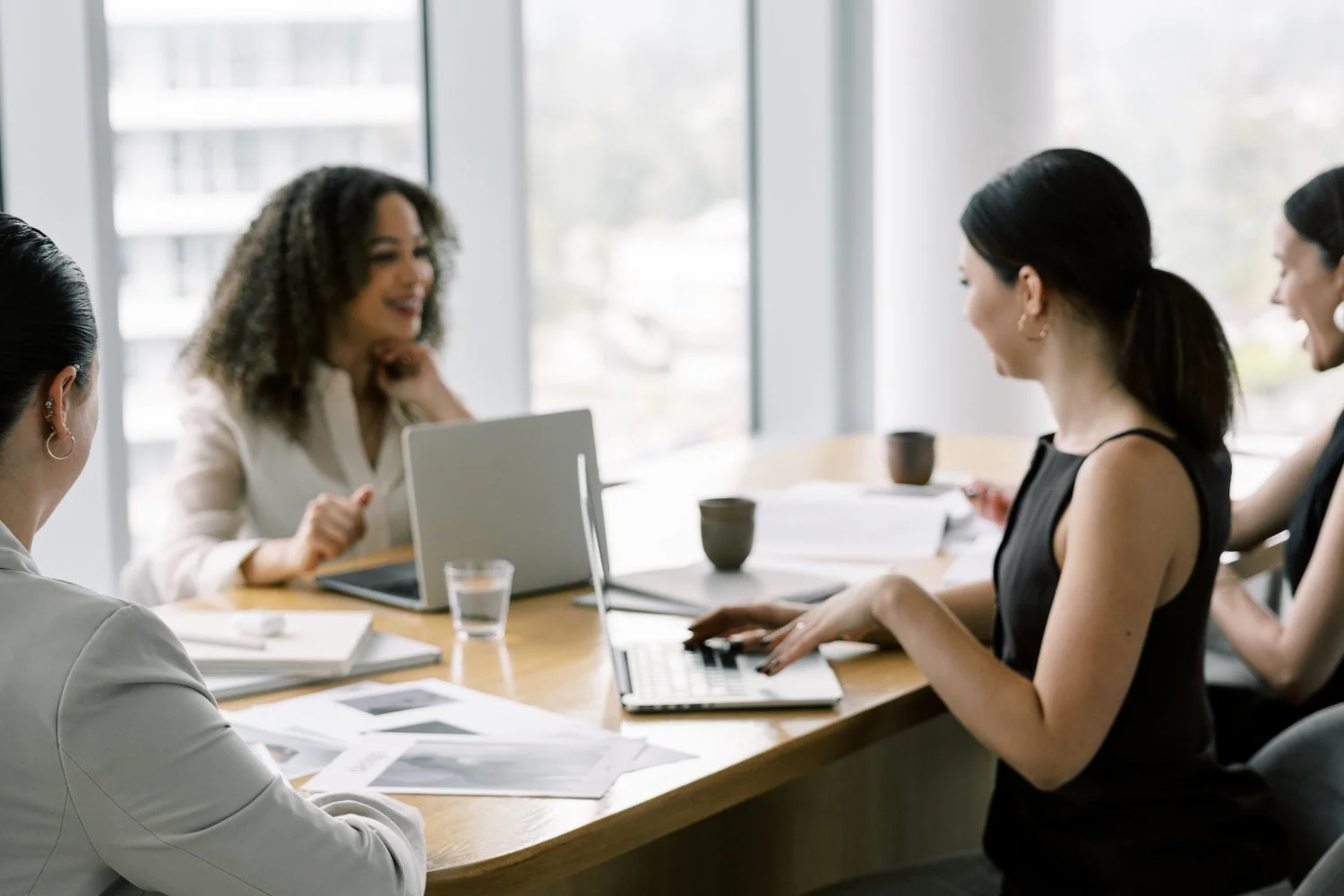 Two women having a conversation across a table in a bright workspace