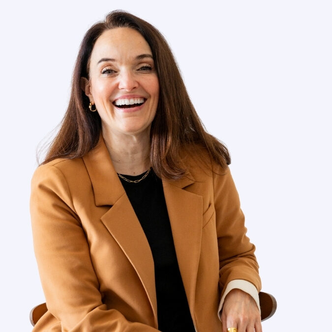 Sarah Walton, business coach and host, laughing in a camel blazer